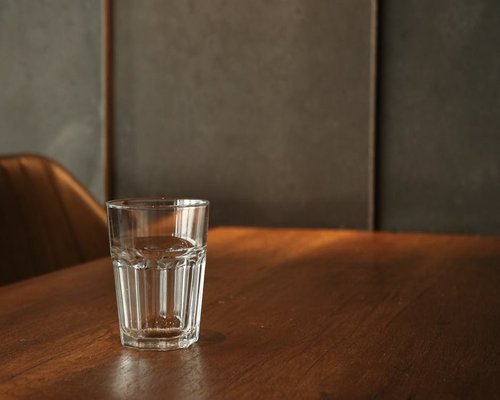 A clear glass of water on a table in a warm environment
